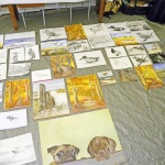 Mehrere Skizzen und Aquarelle auf einem Tisch.