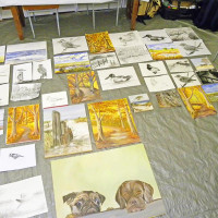 Mehrere Skizzen und Aquarelle auf einem Tisch.
