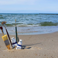 Malutensilien im Sand am Meer