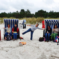 Teilnehmerinnen haben Spaß am Strand in Strandkörben