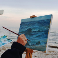 Frau malt Pleinair mit Acryl auf Leinwand am Strand